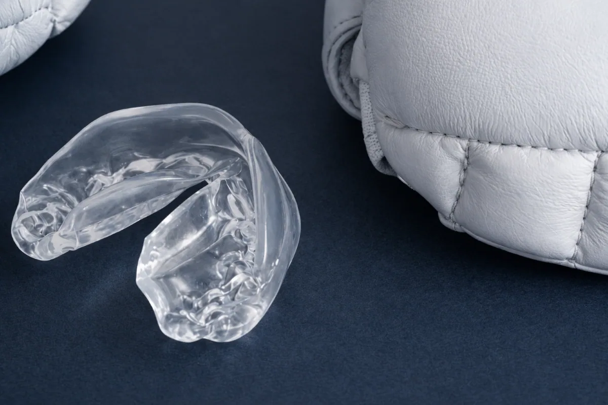 Clear custom occlusal night guard displayed beside boxing gloves in North York.